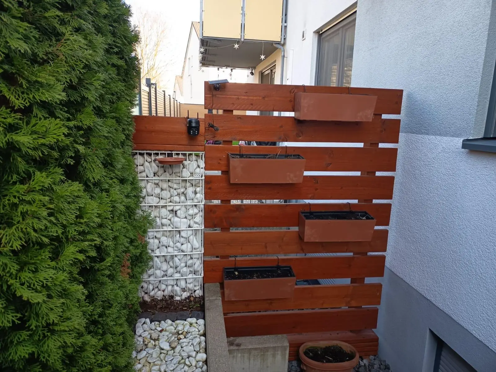 Sichtschutzzaun aus Holz an einer Grundstücksgrenze